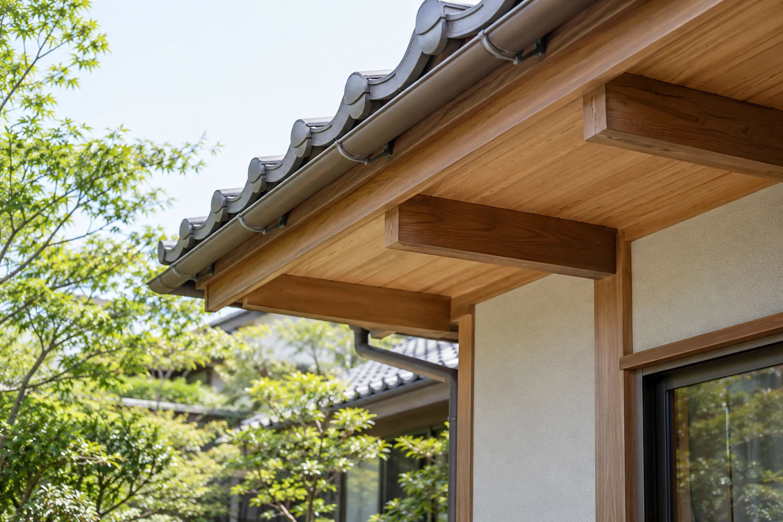 瓦屋根の木造住宅の軒下と庭の緑