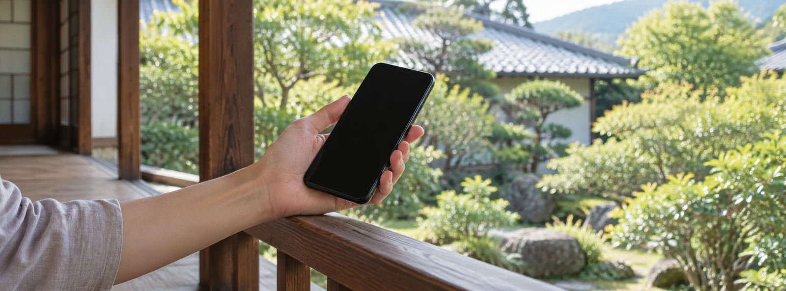 庭を望む縁側で相談用のスマートフォンを持つ手元